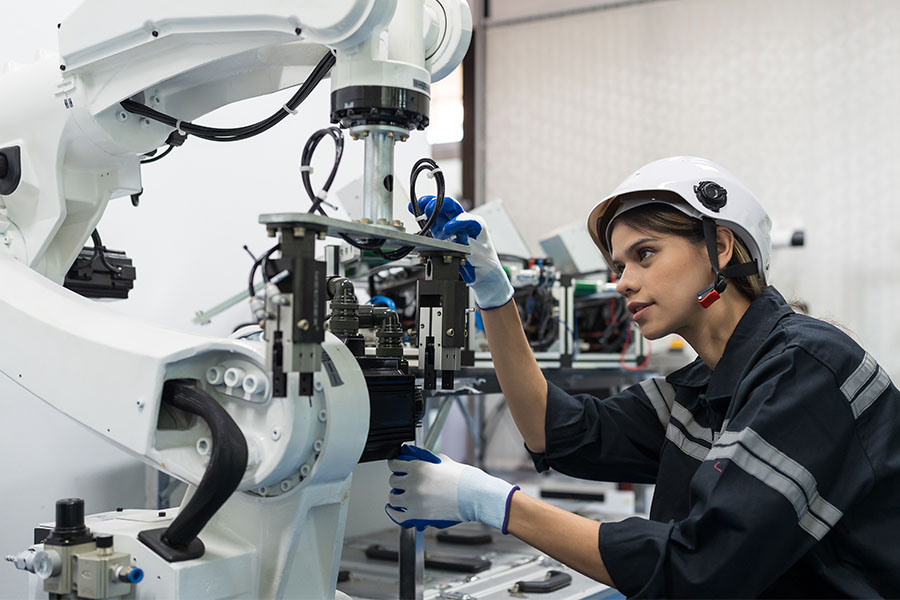 Woman inspecting a robotic arm