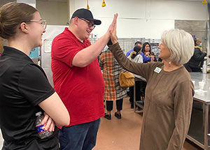 A Hugs Program student gives an instructor a high five.