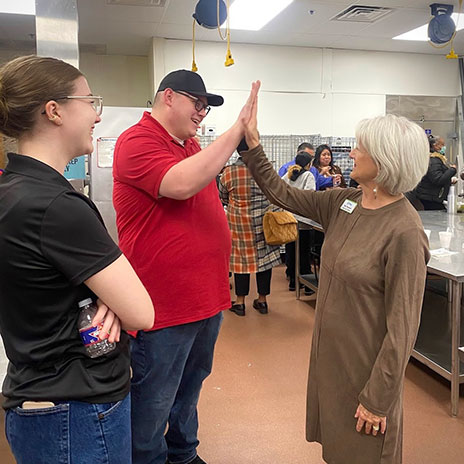 A Hugs Program student gives an instructor a high five.