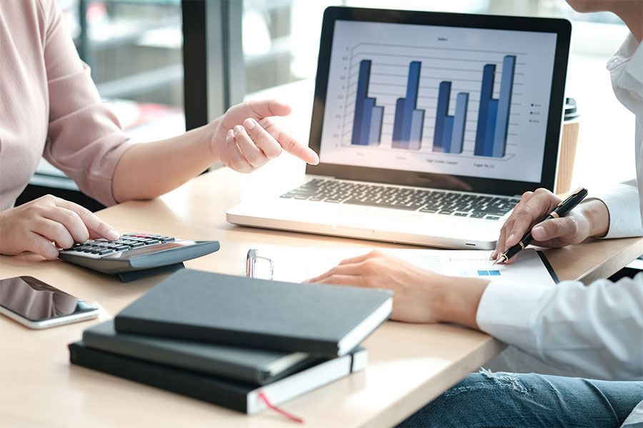 People sitting at a computer displaying bar charts.